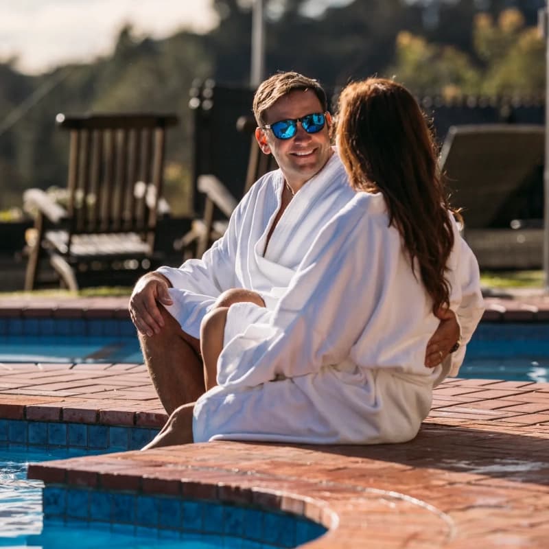 Couple relaxing by the pool at Kimi Ora Resort