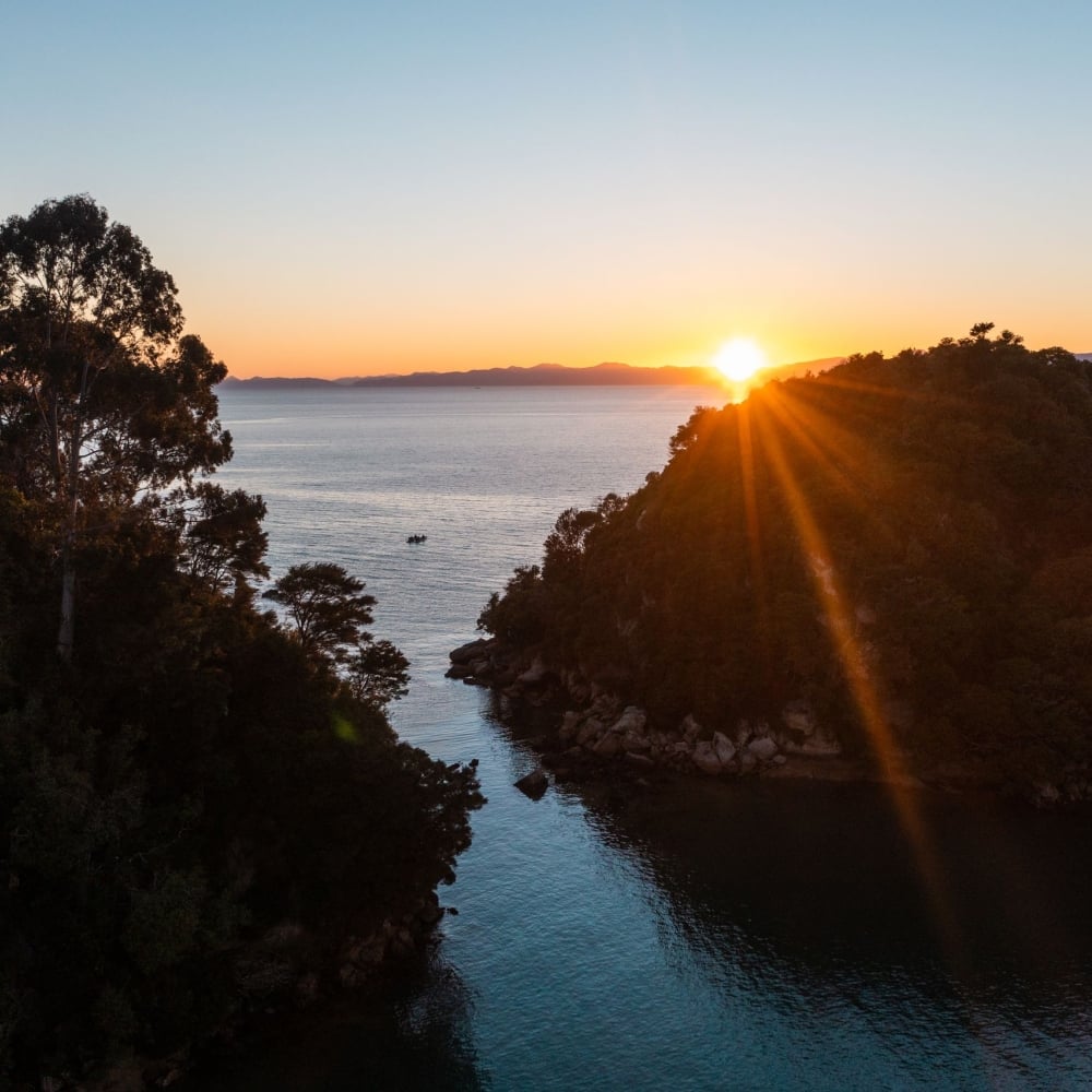 Sunrise in Kaiteriteri paints the sky with golden hues, perfectly complementing its sparkling sands.