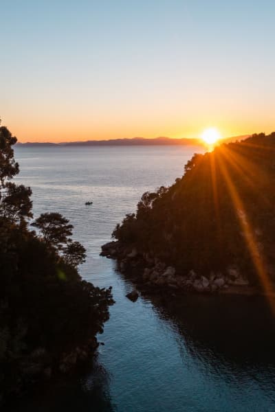 Sunrise in Kaiteriteri paints the sky with golden hues, perfectly complementing its sparkling sands.