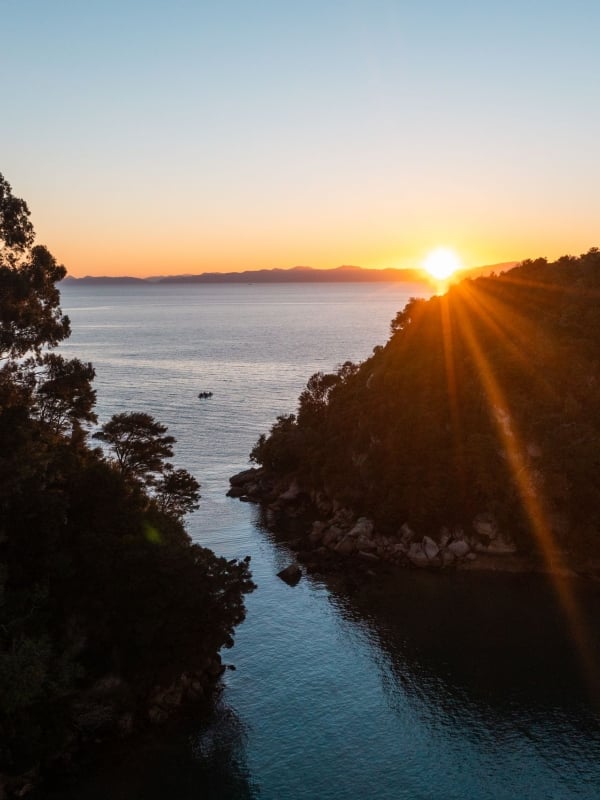Sunrise in Kaiteriteri paints the sky with golden hues, perfectly complementing its sparkling sands.