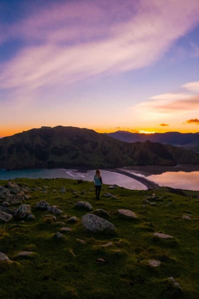 Catch the golden hour at Cable Bay, where the sky lights up over turquoise waters, rocky outcrops, and sweeping coastal views.