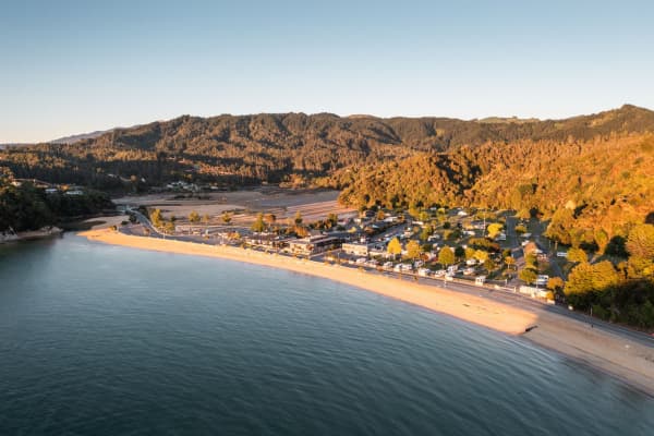 Soak up the sun at Kaiteriteri Beach, where golden sands and crystal-clear waters mark the gateway to Abel Tasman National Park.
