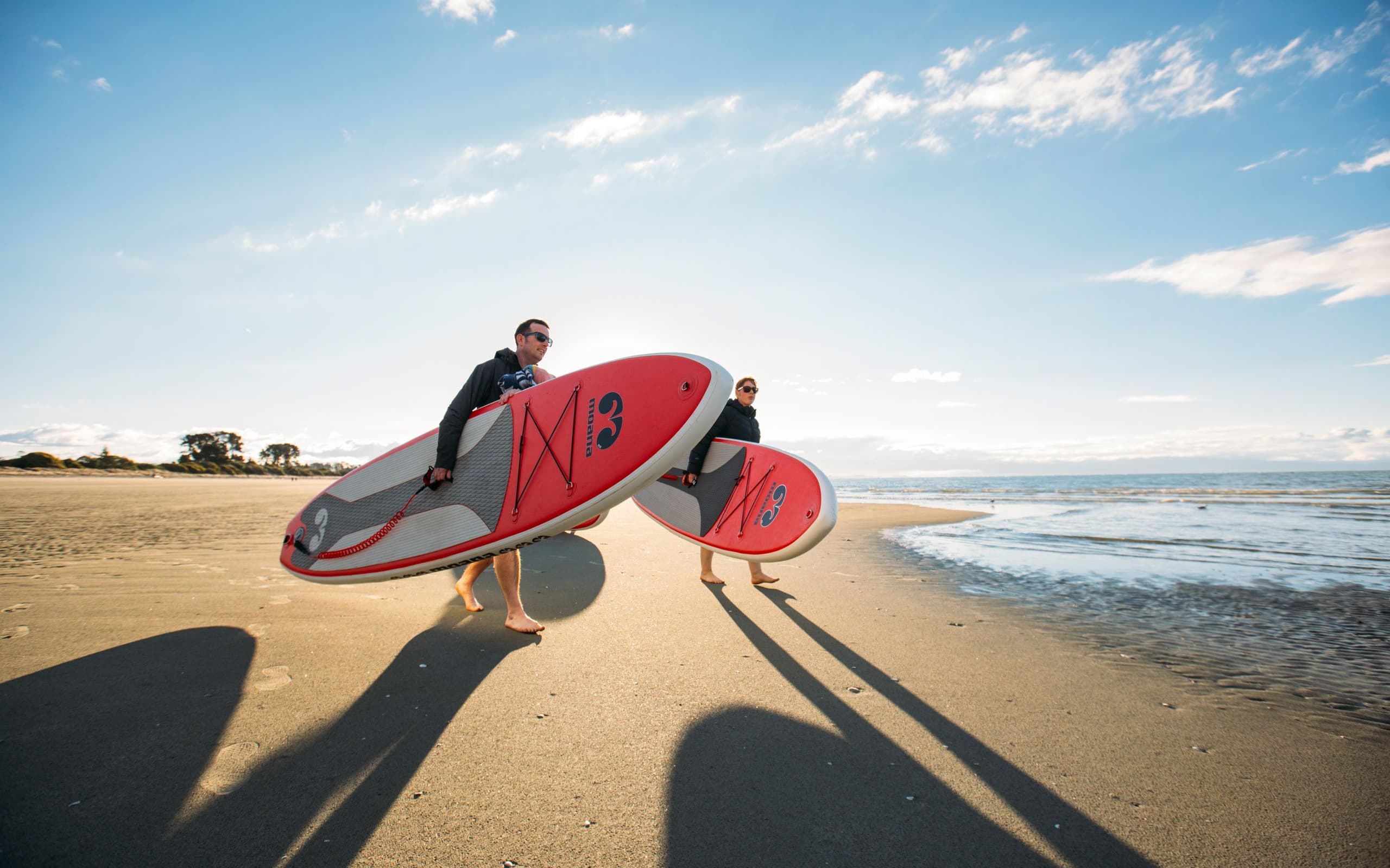 Walking to Water With Paddleboards at Tahunanui Beach