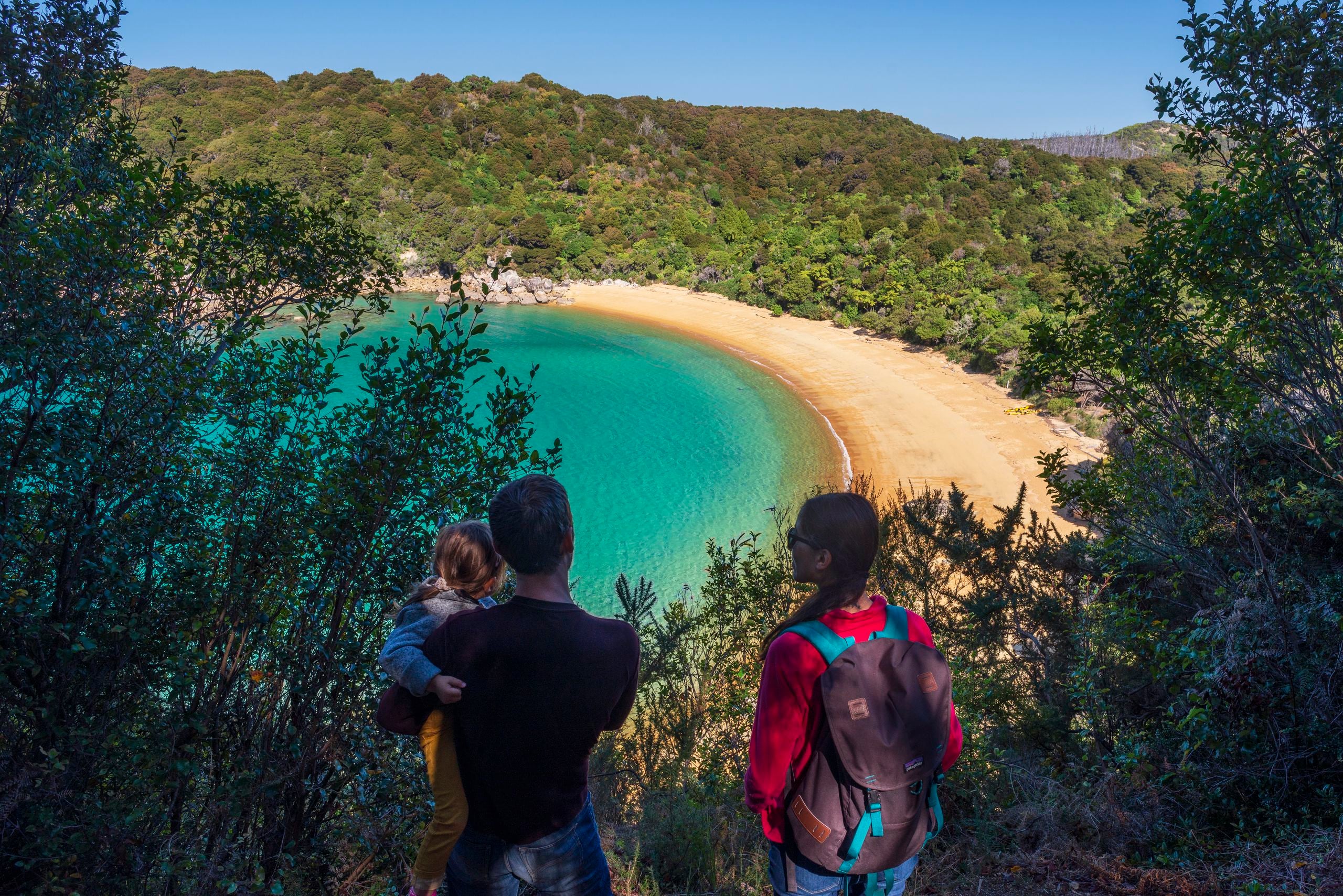 Family walking at Te Puketea in Abel Tasman National Park.